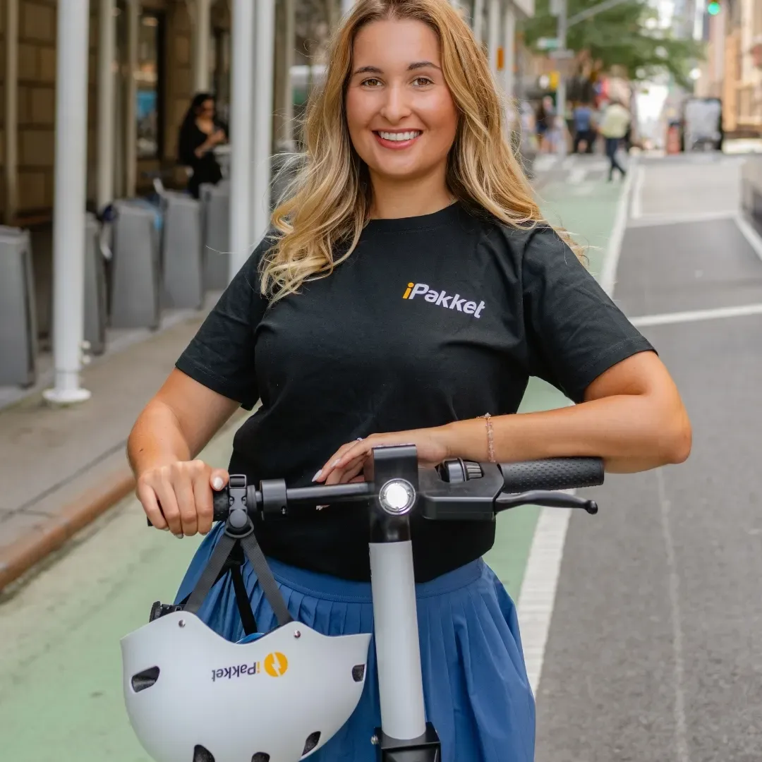 Rider with a Ride by iPakket shared e-scooter in a protected New York City bike lane