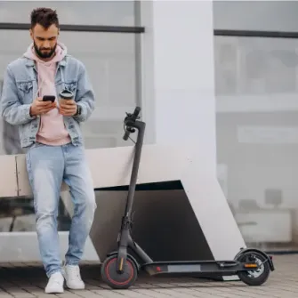 Rider checking the Ride by iPakket app beside a parked e-scooter